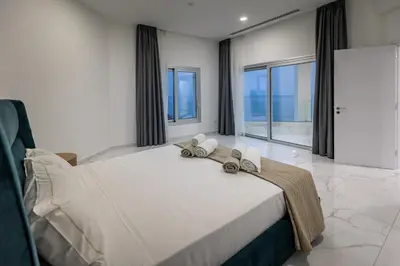 a bedroom with a large bed with towels on it at Mediterranean Dream Beachfront Villa in Larnaka