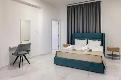 a bedroom with a blue bed with a desk and a chair at Mediterranean Dream Beachfront Villa in Larnaka