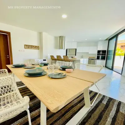 a dining room with a wooden table and chairs at By the Beach Villa 7 in Protaras