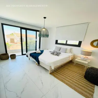 a bedroom with a bed and a large window at By the Beach Villa 7 in Protaras