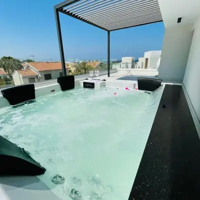 a hot tub in a room with a large window at By the Beach Villa 7 in Protaras