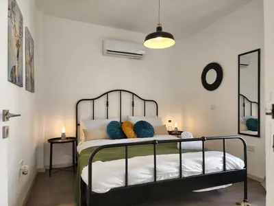 a bedroom with a bed with blue and orange pillows at Lazuli Frida Two Bedroom Apt in Larnaka