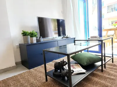 a living room with a glass table and a tv at Lazuli Frida Two Bedroom Apt in Larnaka