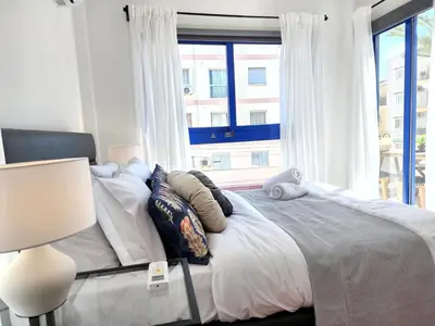 a bedroom with a large bed with a window at Lazuli Frida Two Bedroom Apt in Larnaka