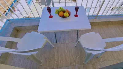 a white table and chairs with a bowl of fruit at STAY Chill n' Joy in Ayia Napa