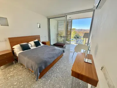 a bedroom with a bed and a view of the canyon at Luxury Villa Pluto Stunning Mountain Views in Ora