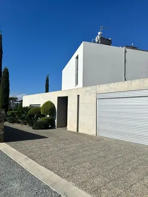 a white house with a garage and a driveway at Luxury Villa Pluto Stunning Mountain Views in Ora