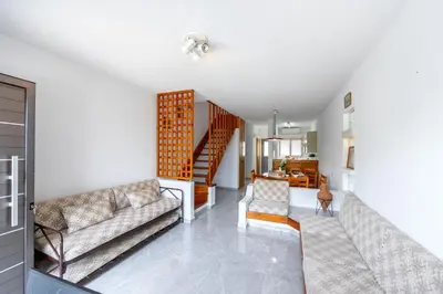 a living room with two couches and a staircase at Maistralli Villa in Protaras