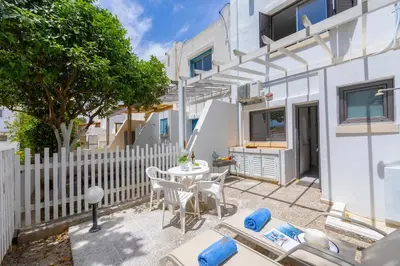 a patio with a white fence and a table and chairs at Maistralli Villa in Protaras