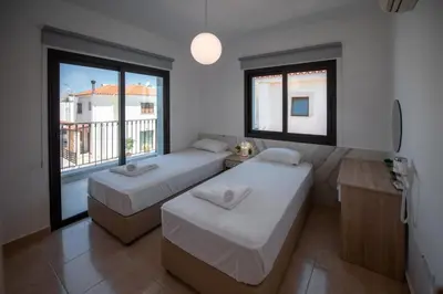 a room with two beds and a large window at Luxury Villa Agathoula in Protaras