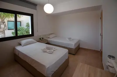 a bedroom with two beds and a window at Luxury Villa Agathoula in Protaras
