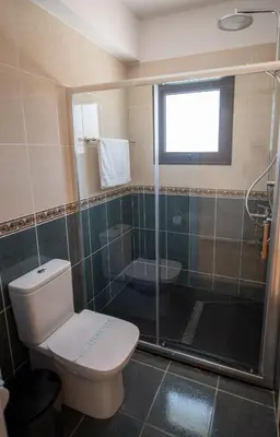 a bathroom with a toilet and a glass shower at Luxury Villa Agathoula in Protaras