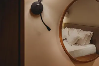 a mirror on a wall next to a bed with pillows at Andama Country Living in Pano Lefkara