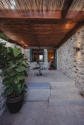 a patio with a table and chairs and a brick wall at Andama Country Living in Pano Lefkara
