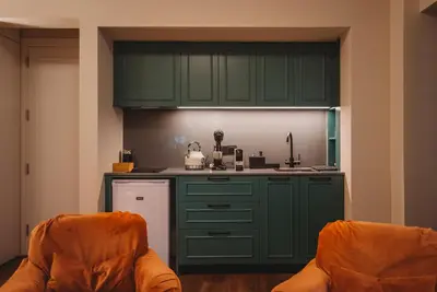 a kitchen with green cabinets and two chairs at Andama Country Living in Pano Lefkara