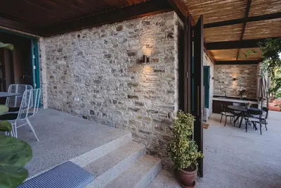 an outdoor patio with a brick wall and tables and chairs at Andama Country Living in Pano Lefkara