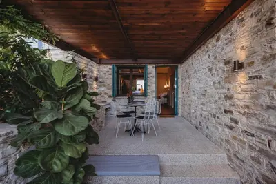 a stone walled patio with a table and chairs at Andama Country Living in Pano Lefkara