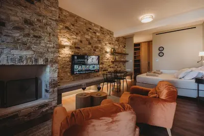 a living room with a large stone wall at Andama Country Living in Pano Lefkara