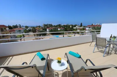 a balcony with a table and chairs on a roof at Nissi 3 Amazing Sea View Apartment in Ayia Napa