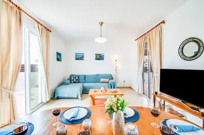 a living room with a blue couch and a table at Villa Rosedale by Ezoria Villas in Ayia Napa