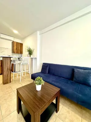 a living room with a blue couch and a table at Serene Napa Suites - Heart of Ayia Napa in Ayia Napa