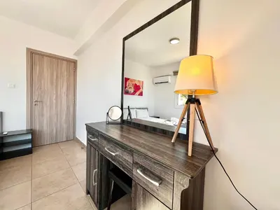 a lamp on a dresser in a room with a mirror at STAY Symphony Apartment in Protaras