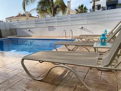 a pool with two chairs and a table next to it at Villa Diana - 200 meters from Kapparis, Fireman's Beach in Paralimni