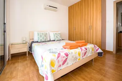 a bedroom with a bed with orange towels on it at SEABREEZE APARTMENT 200m away from the sea in Paralimni