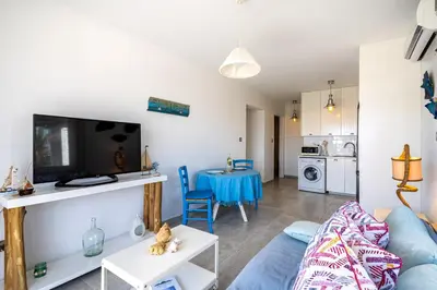 a living room with a blue couch and a table at Seawaves 1- Bedroom Apartment near Meneou Beach in Larnaka