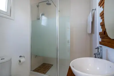 a bathroom with a glass shower and a sink at Seawaves 1- Bedroom Apartment near Meneou Beach in Larnaka
