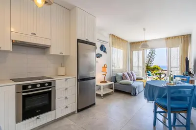 a kitchen with a stove and a table in a room at Seawaves 1- Bedroom Apartment near Meneou Beach in Larnaka