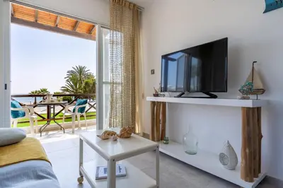 a living room with a tv and a balcony at Seawaves 1- Bedroom Apartment near Meneou Beach in Larnaka
