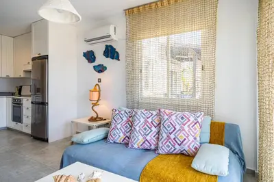 a living room with a blue couch with pillows at Seawaves 1- Bedroom Apartment near Meneou Beach in Larnaka