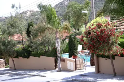 a view of a resort with palm trees and a pool at Eve Pissouri Soultanina Villa in Pissouri