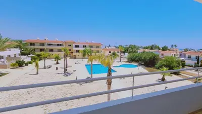 a view of a beach with palm trees and buildings at Nissi 3 Privileges Apt in Ayia Napa