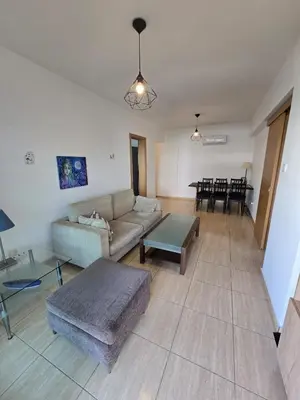 a living room with a couch and a table at Carisa DownTown with Rooftop pool in Larnaka