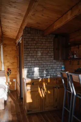 a kitchen with wooden cabinets and a brick wall at Bosco Paradiso in Limassol