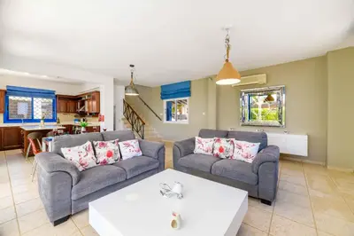 a living room with two couches and a table at Villa Serena Springs by Ezoria Villas in Protaras