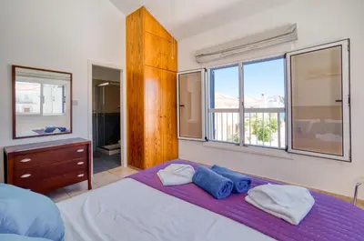 a bedroom with a bed with two towels on it at Villa Serena Springs by Ezoria Villas in Protaras