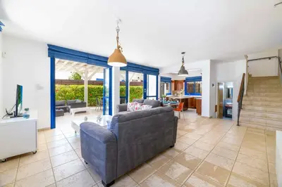a living room with a couch and a tv at Villa Serena Springs by Ezoria Villas in Protaras