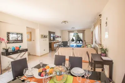 a dining room and living room with a table and chairs at Artemisia Villa in Protaras