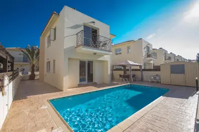 a villa with a swimming pool in front of a house at Antonia Villa in Protaras
