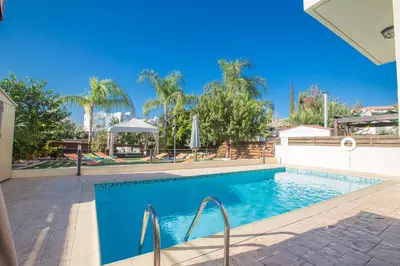 a swimming pool in a villa with palm trees at Antonia Villa in Protaras