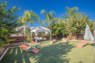 a yard with lounge chairs and an umbrella at Antonia Villa in Protaras
