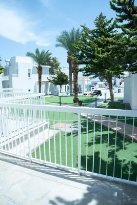 a white fence in front of some trees at Flisvos Beach Apartments in Protaras