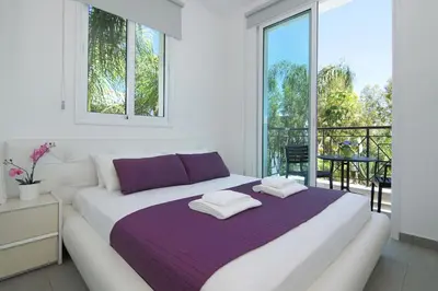 a white bed in a room with a balcony at Villa Blue Oasis in Protaras