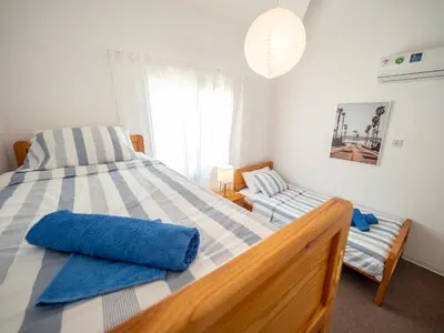 a bedroom with a large bed with blue pillows on it at The Salnik Beach Apartment in Limassol