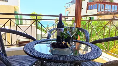 a table with a bottle of wine and a bowl of fruit at The Salnik Beach Apartment in Limassol