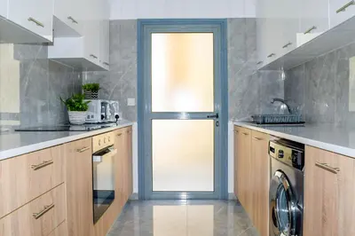 a kitchen with a door leading to a dishwasher at Coastal Getaway in Larnaka