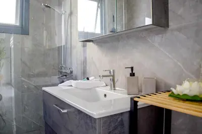 a bathroom with a white sink and a shower at Coastal Getaway in Larnaka